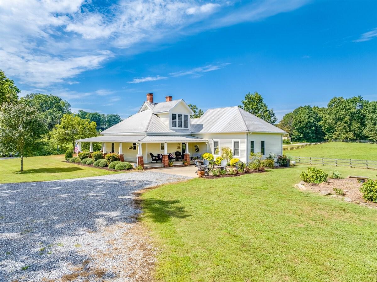 Close exterior view of Shoal Creek Acres farmhouse and wraparound porch