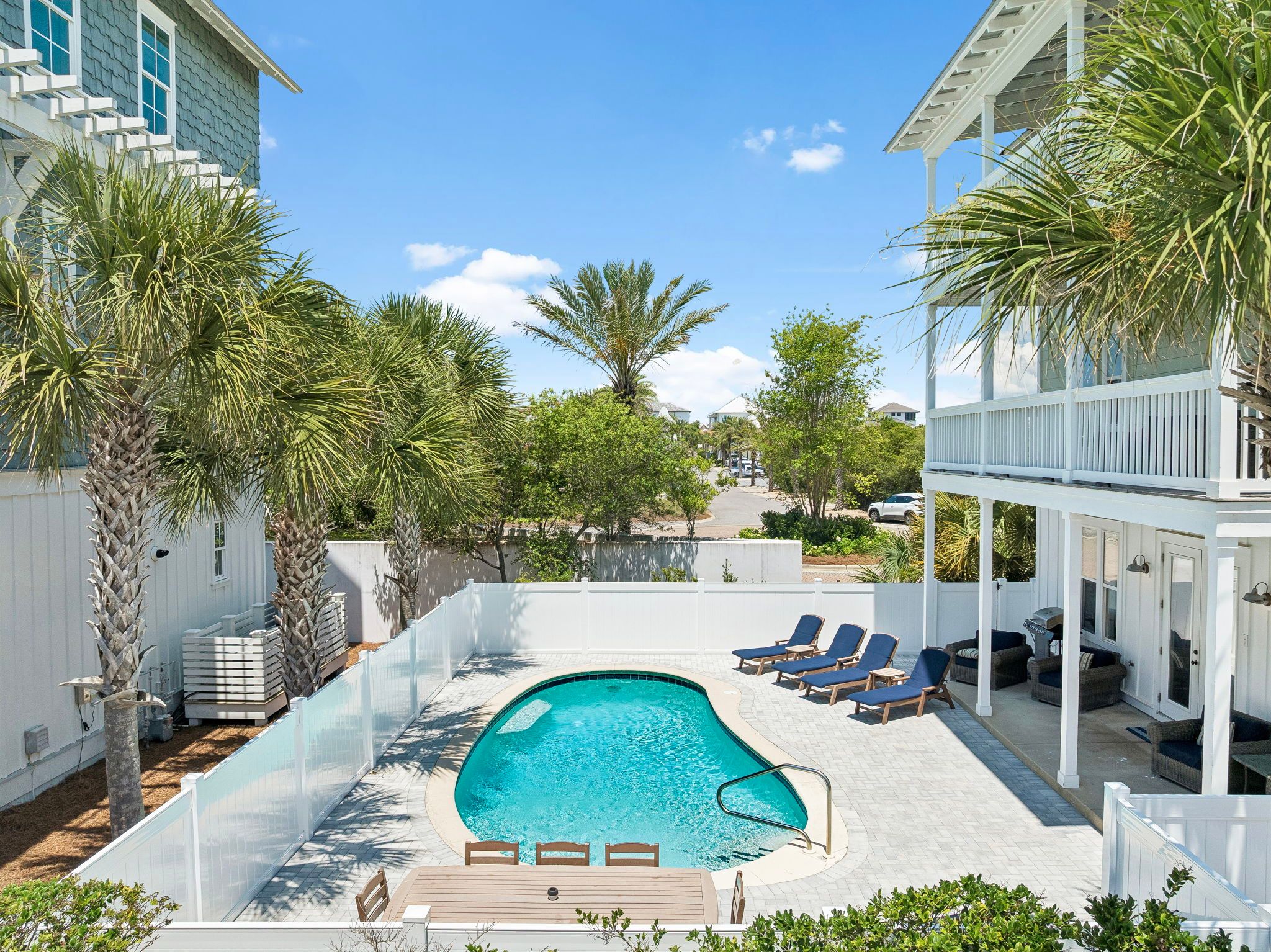 Sunny private pool deck framed by palms