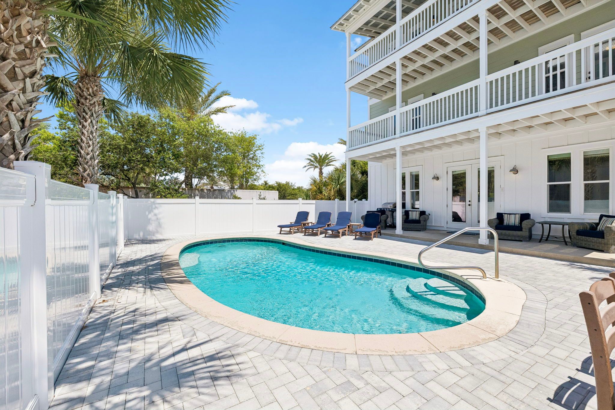Resort-style pool with loungers and covered seating