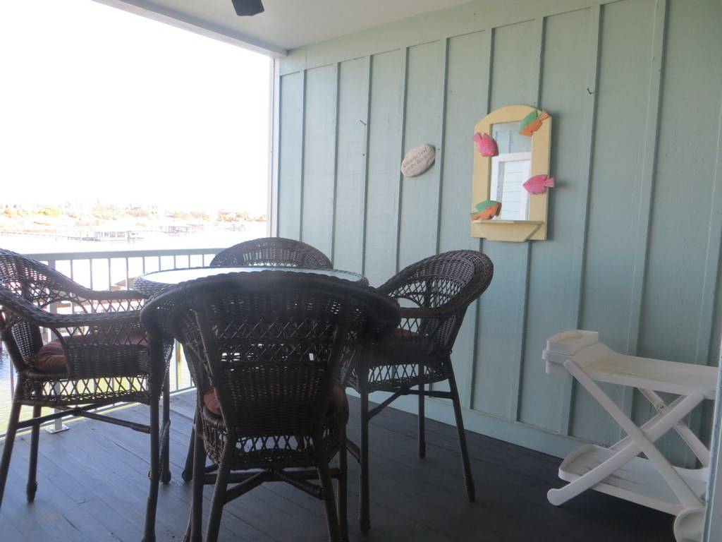 large balcony with coastal patio furniture and stunning views during the day and night of Old River and Ono Island