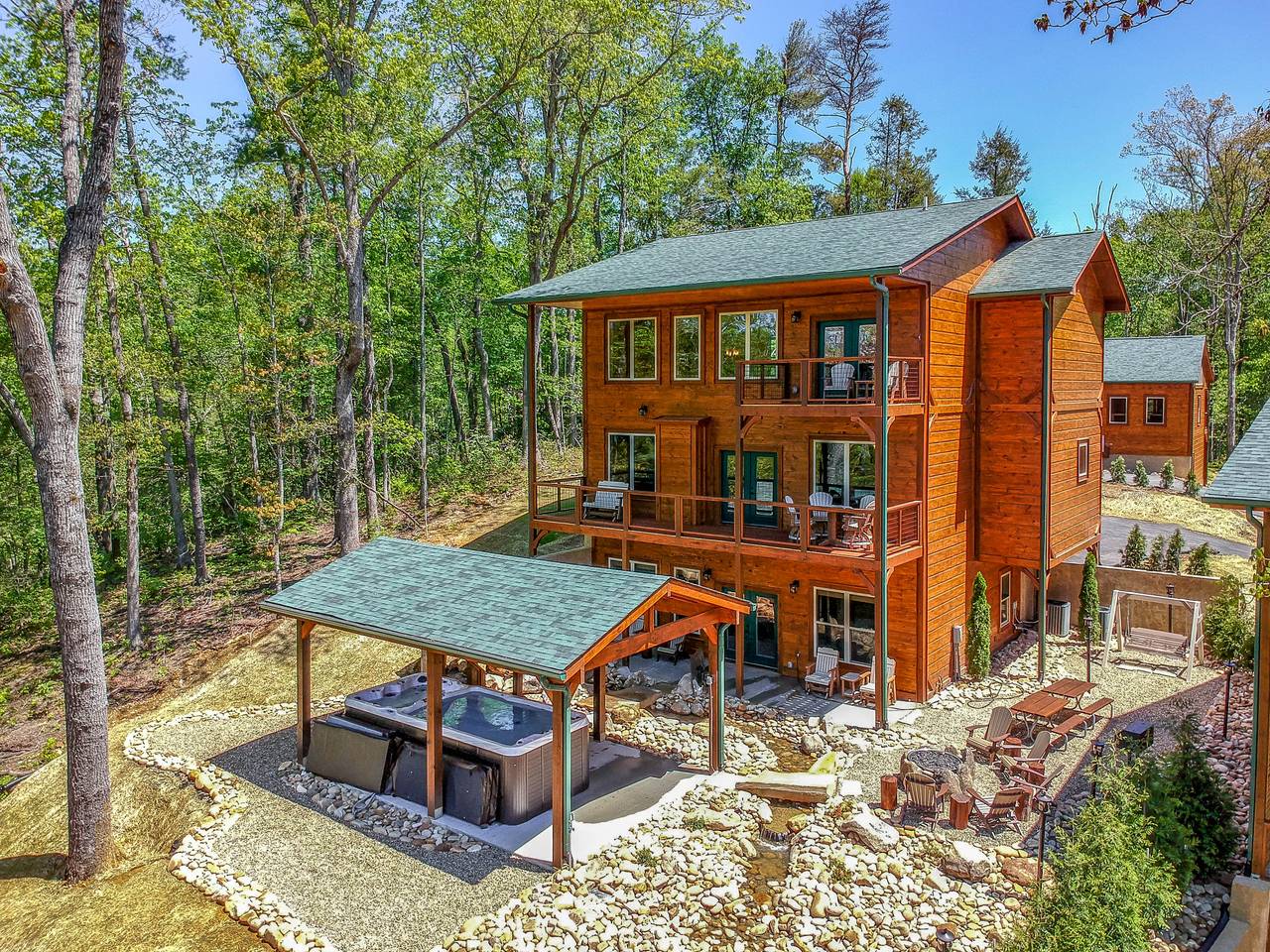 Resort-style backyard featuring swim spa, hot tub, and firepit Resort-style backyard featuring swim spa, hot tub, and firepit