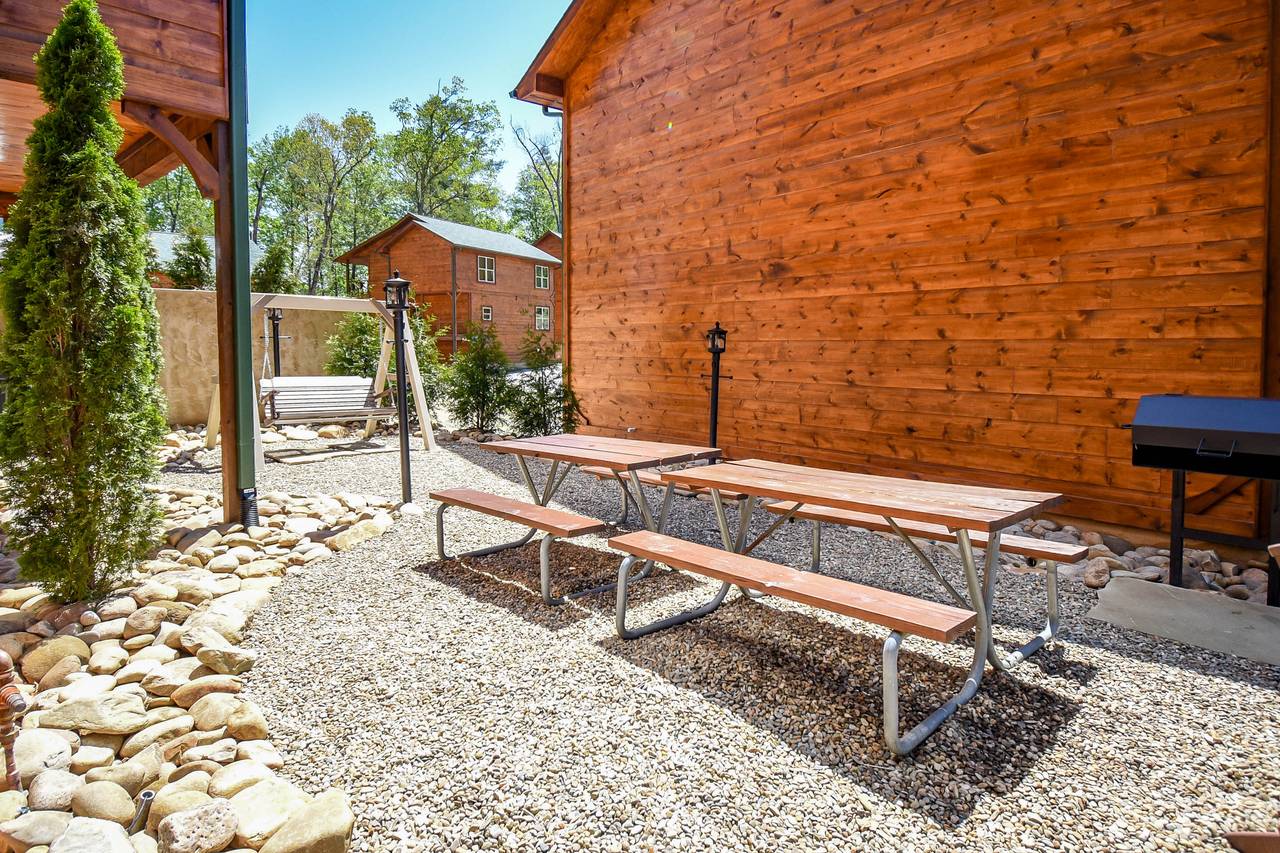 Charcoal grill ready and picnic tables for mountain cookouts Charcoal grill ready and picnic tables for mountain cookouts