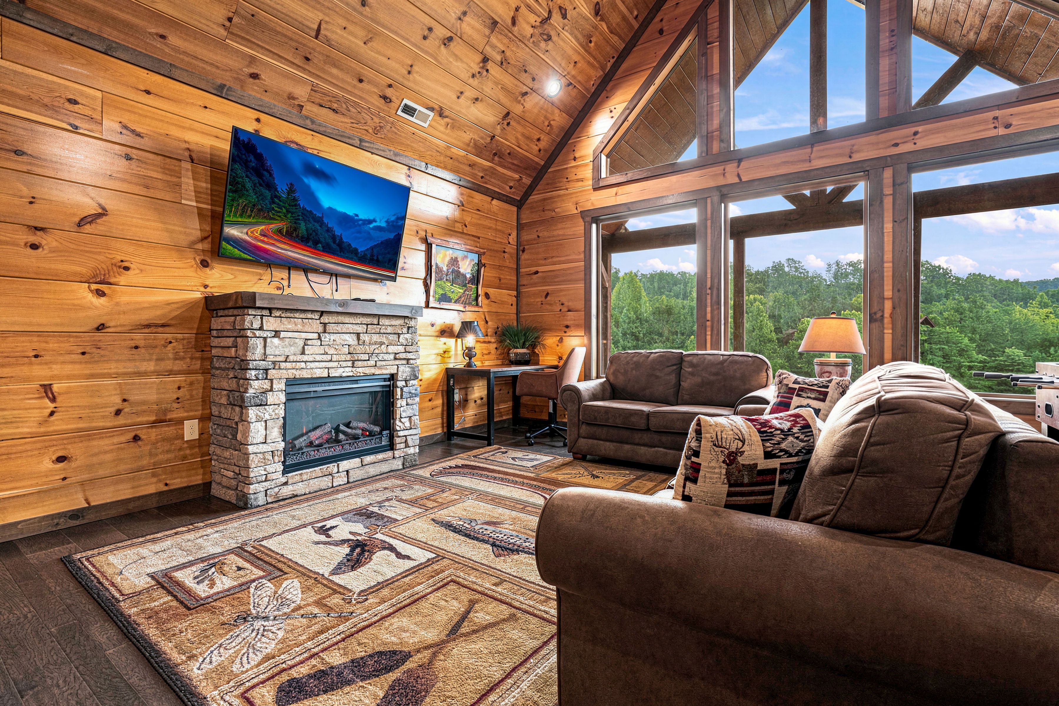Upper living room with electric fireplace and large TV.