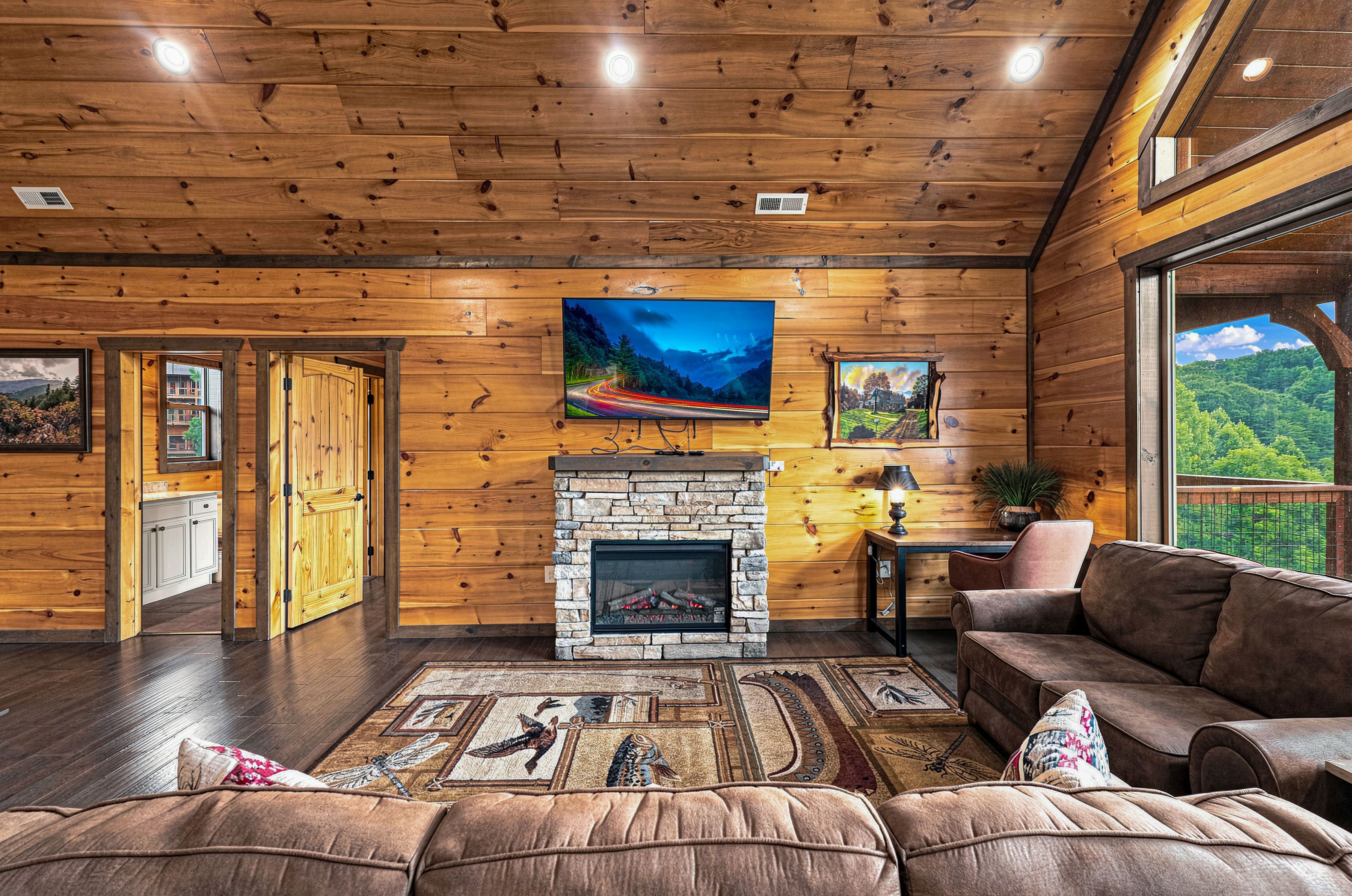Upper living room with electric fireplace and large TV.