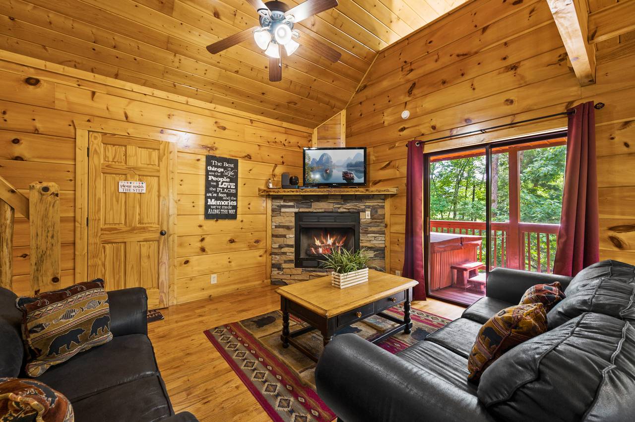 Living room with fireplace, TV, sleeper sofa, and deck entrance Living room with fireplace, TV, sleeper sofa, and deck entrance