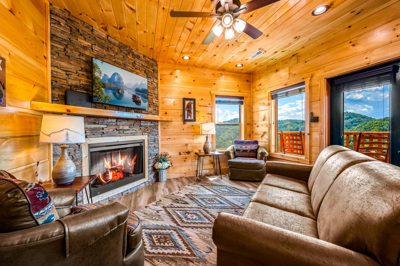 Spacious living room with fireplace, TV, & a queen sleeper sofa. Spacious living room with fireplace, TV, & a queen sleeper sofa.