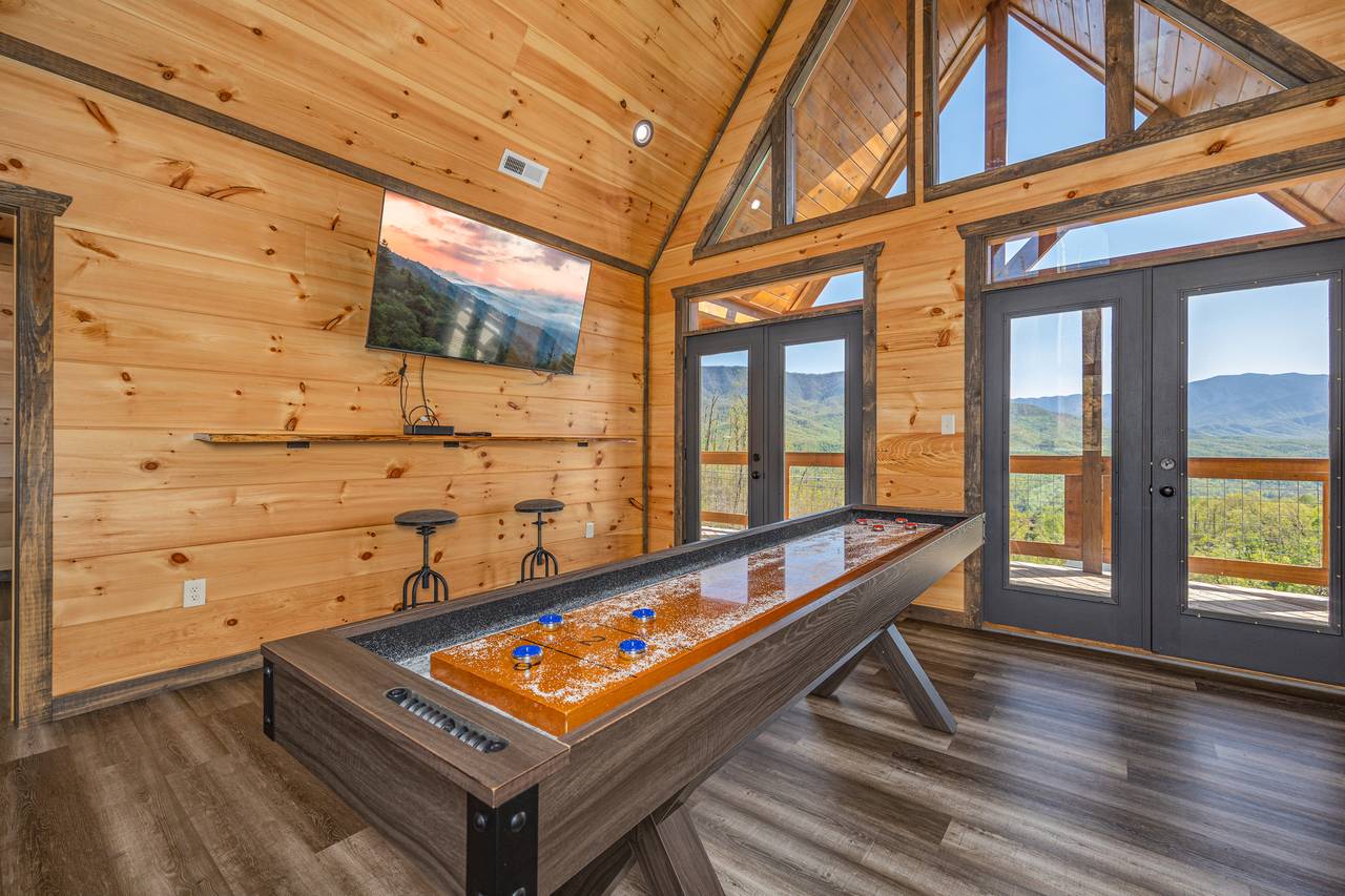 Upper level entertainment room w/TV, shuffle board & arcade Upper level entertainment room w/TV, shuffle board & arcade