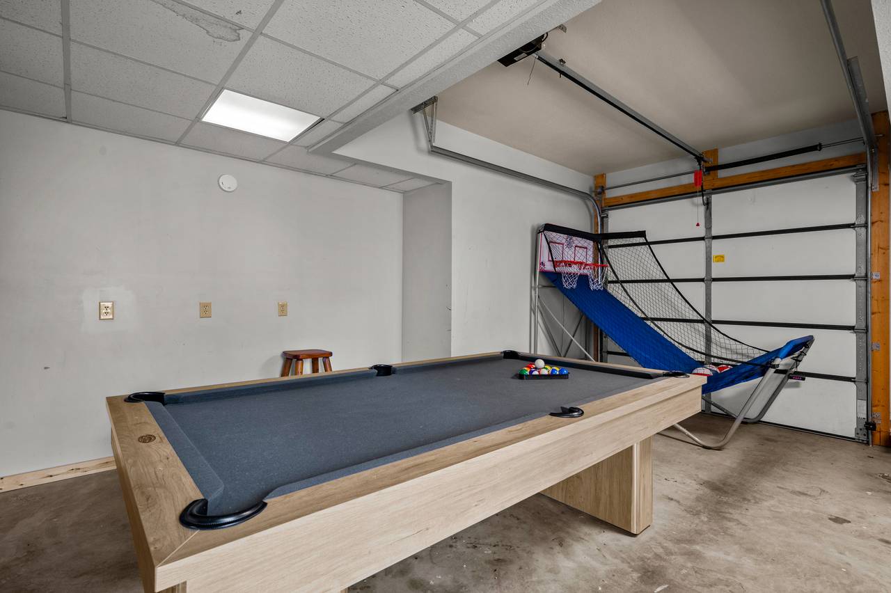 Pool table and basketball in garage area Pool table and basketball in garage area