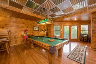 Lower level media room with sofa, TV, and pool table Lower level media room with sofa, TV, and pool table