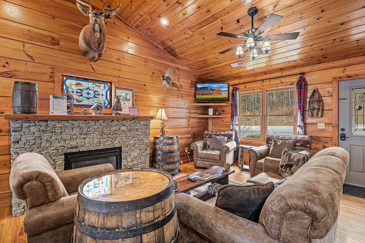 <span class="name">Living room with fireplace, TV, and comfy couch and chairs</span> <span class="name">Living room with fireplace, TV, and comfy couch and chairs</span>