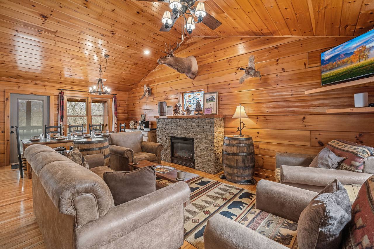 <span class="name">Living room with fireplace, TV, and comfy couch and chairs</span> <span class="name">Living room with fireplace, TV, and comfy couch and chairs</span>