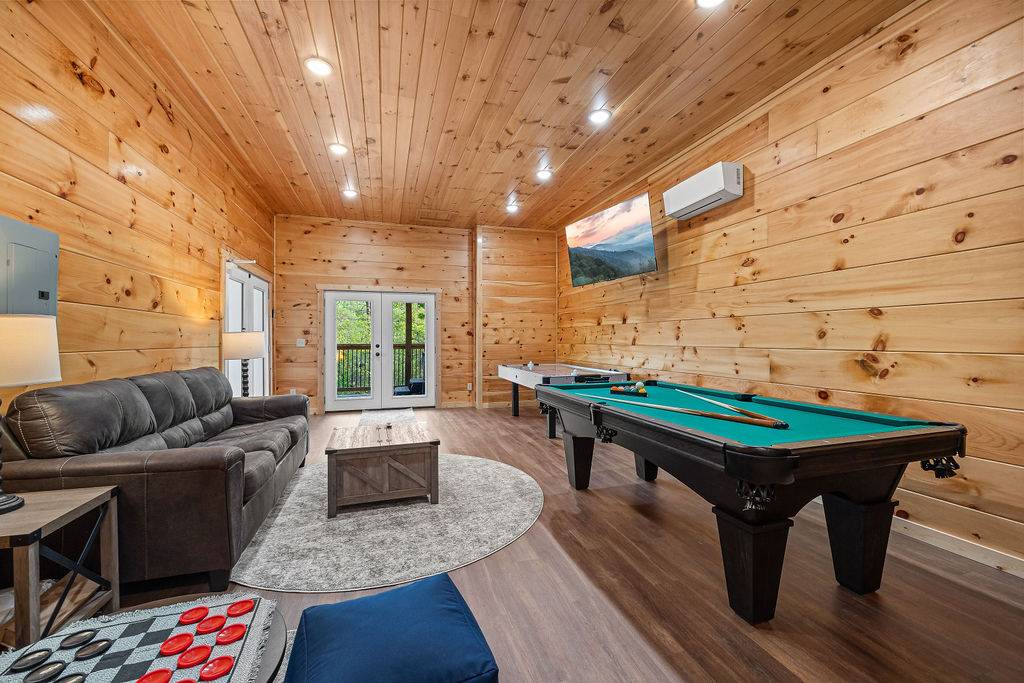 Lower level game room with comfy sofa, pool table, & air hockey