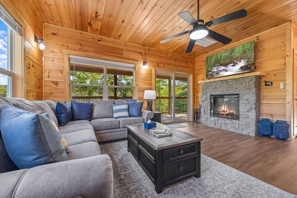 Living room with electric fireplace, TV, and wraparound sofa