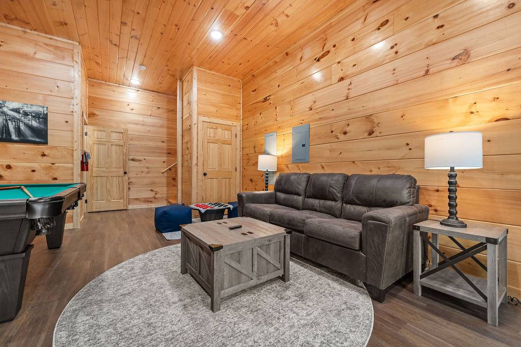 Lower level game room with comfy sofa, pool table, & air hockey
