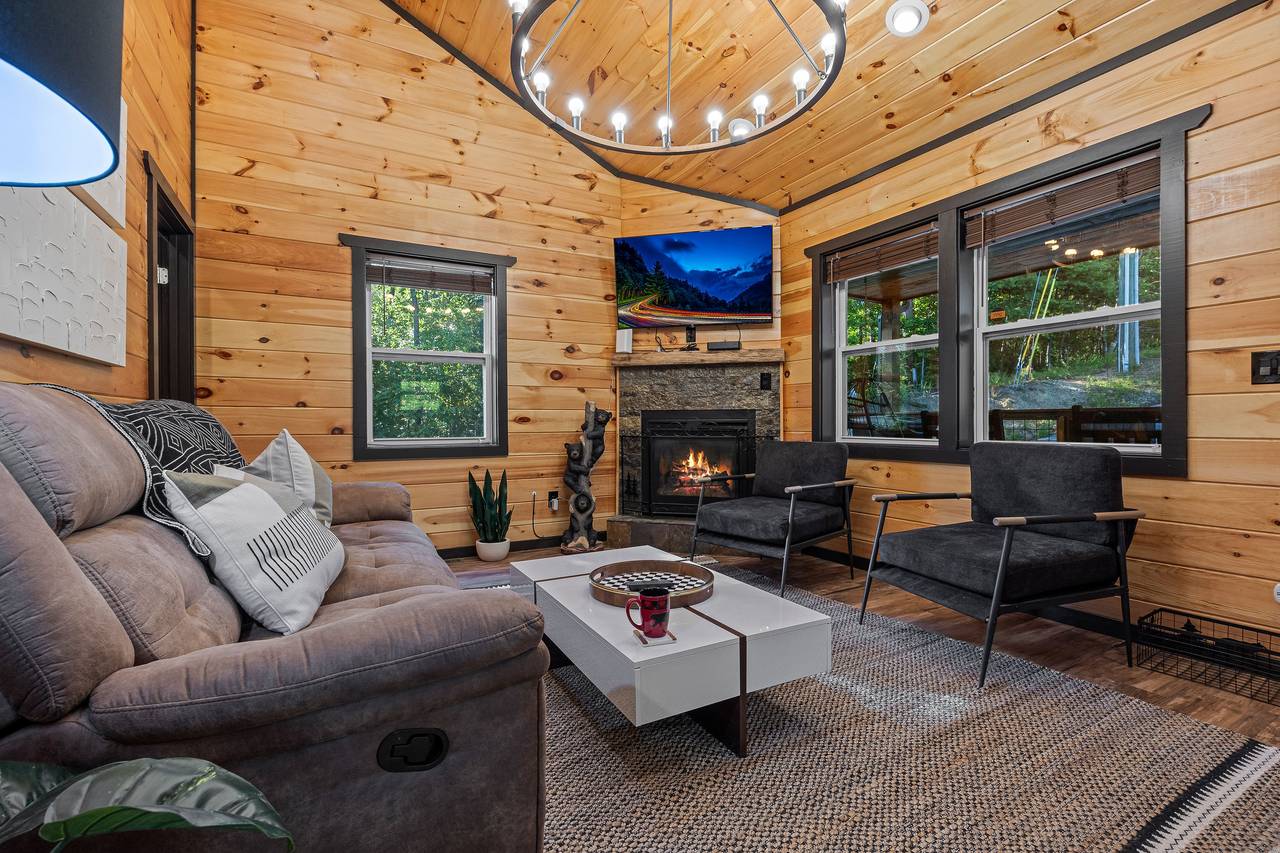 Spacious living room with reclining chair, fireplace, & TV. Spacious living room with reclining chair, fireplace, & TV.