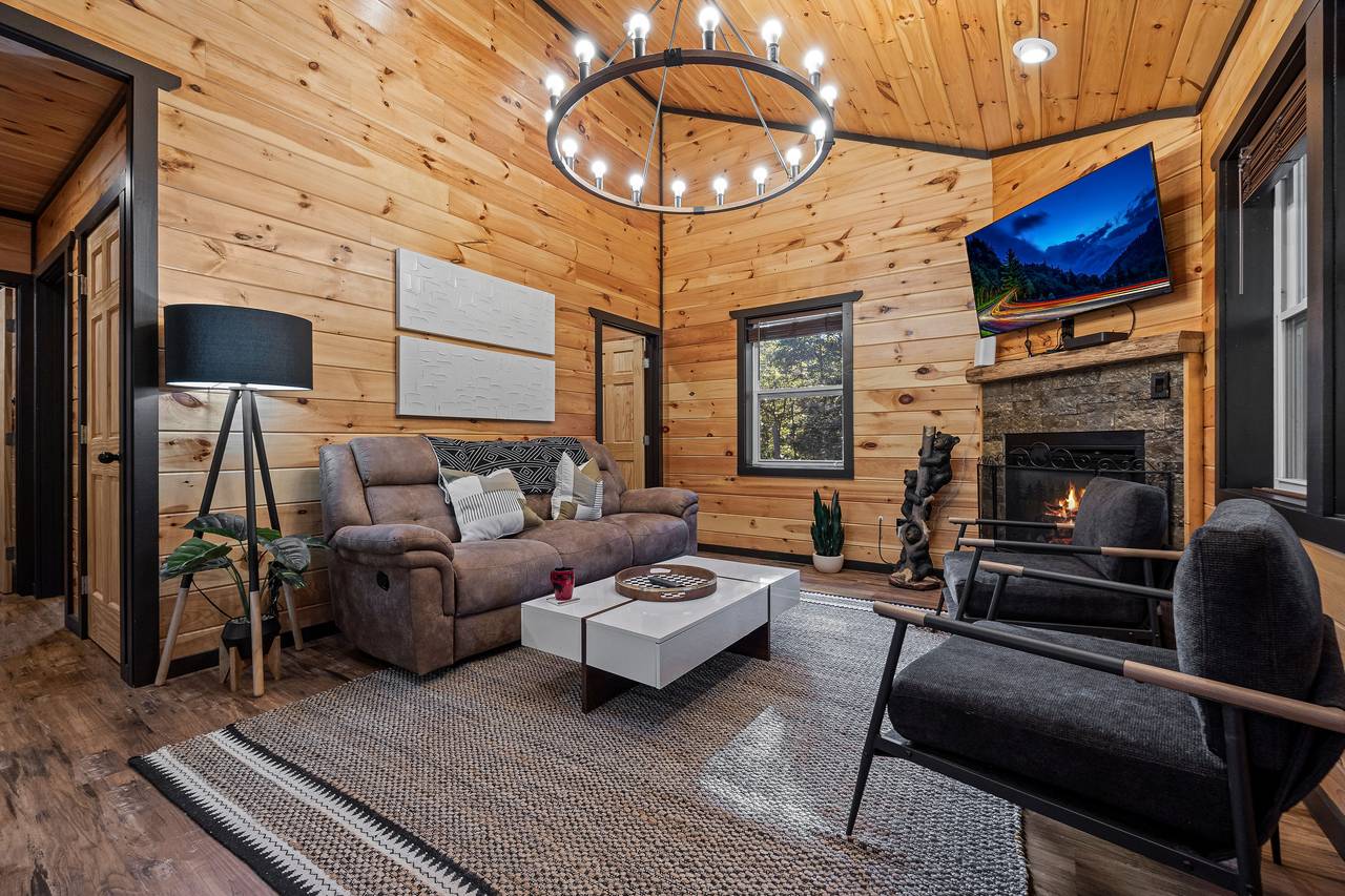 Spacious living room with reclining chair, fireplace, & TV. Spacious living room with reclining chair, fireplace, & TV.