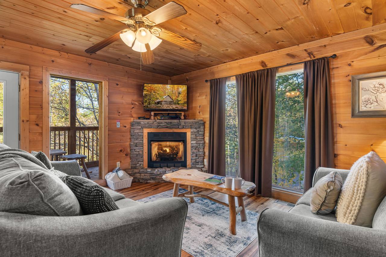 Cozy living room with stone fireplace & warm cabin décor Cozy living room with stone fireplace & warm cabin décor