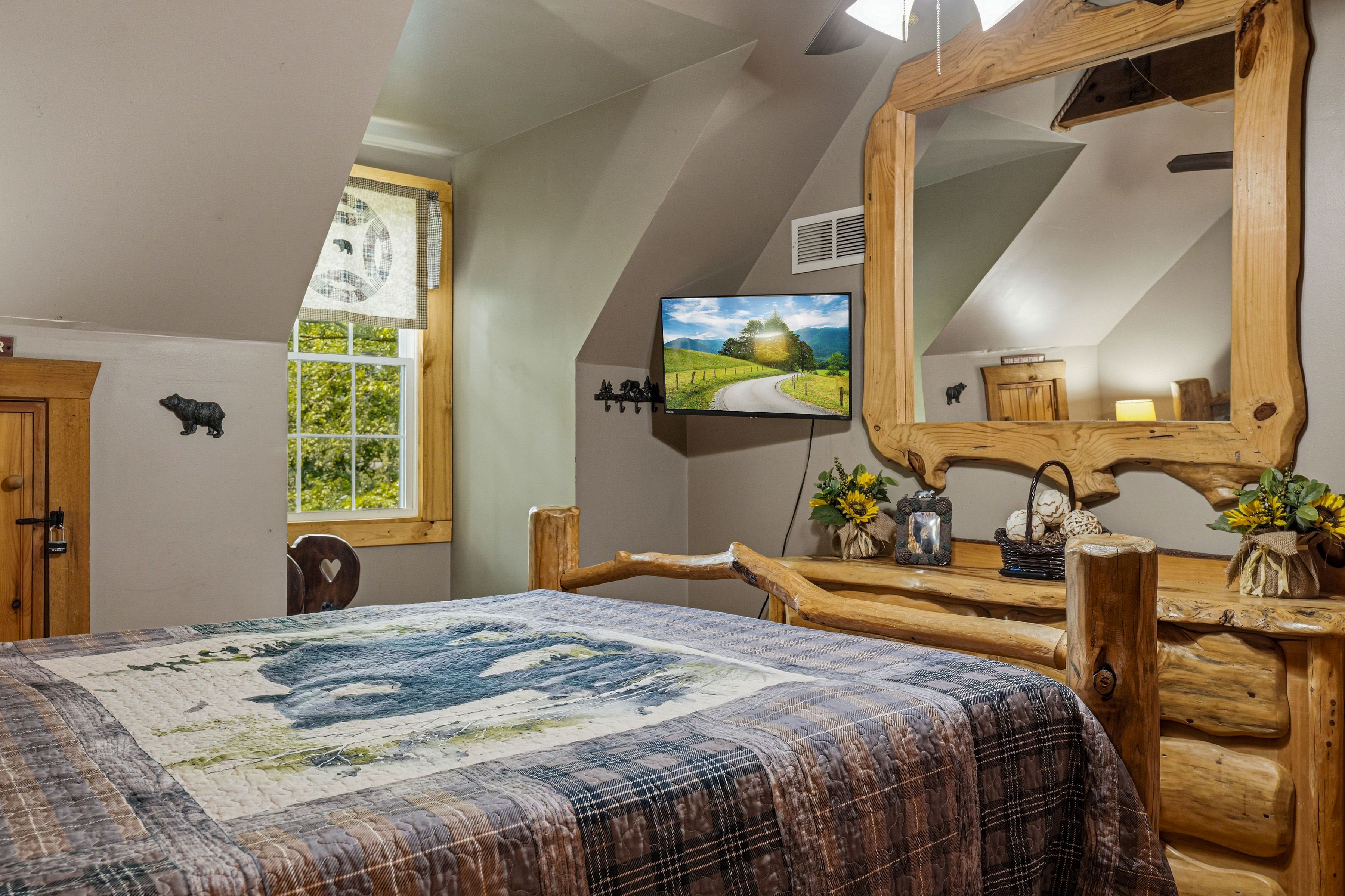 <span class="name">Upper-level bedroom with a comfortable queen bed & TV</span>