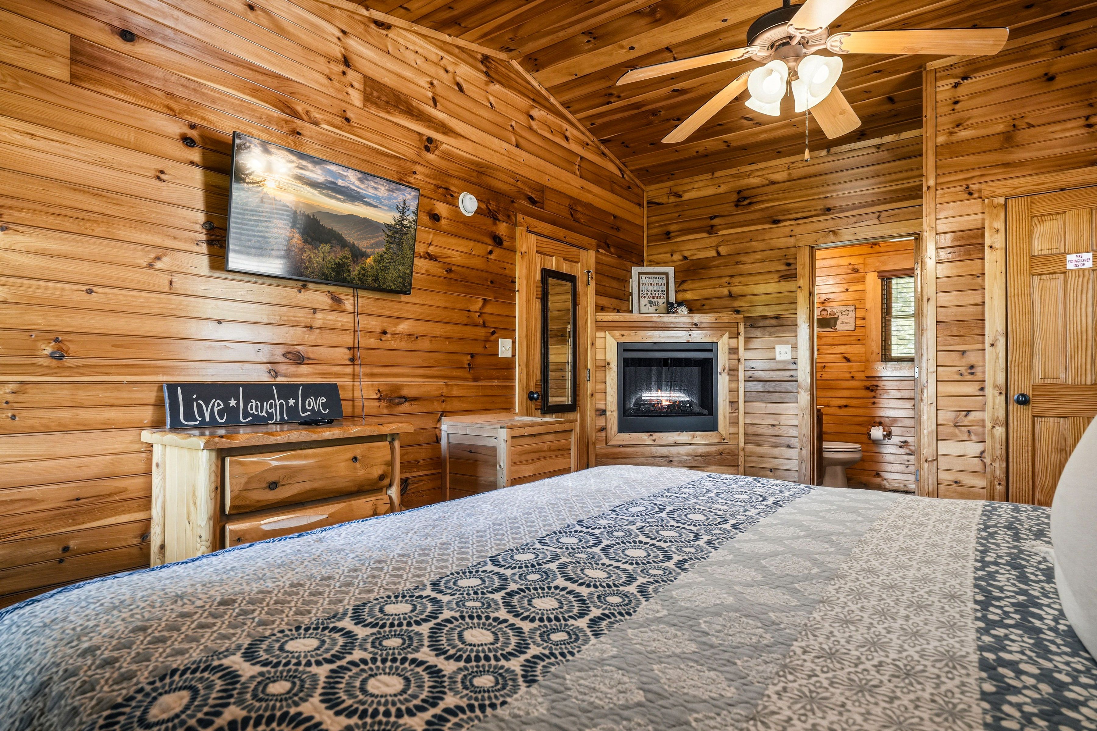 King bedroom with cozy electric fireplace