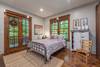 Queen bedroom with doors out to deck and patio area.