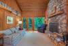 Den on main level w/ wood fireplace and doors out to deck.