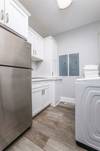 Laundry room with extra fridge off kitchen