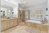 Master bathroom with soaking tub, shower with double heads, and two vanities.