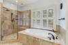 Master bathroom with soaking tub, shower with double heads, and two vanities.