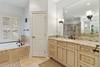 Master bathroom with soaking tub, shower with double heads, and two vanities.