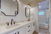 Shared hall bathroom with double vanity and shower/tub