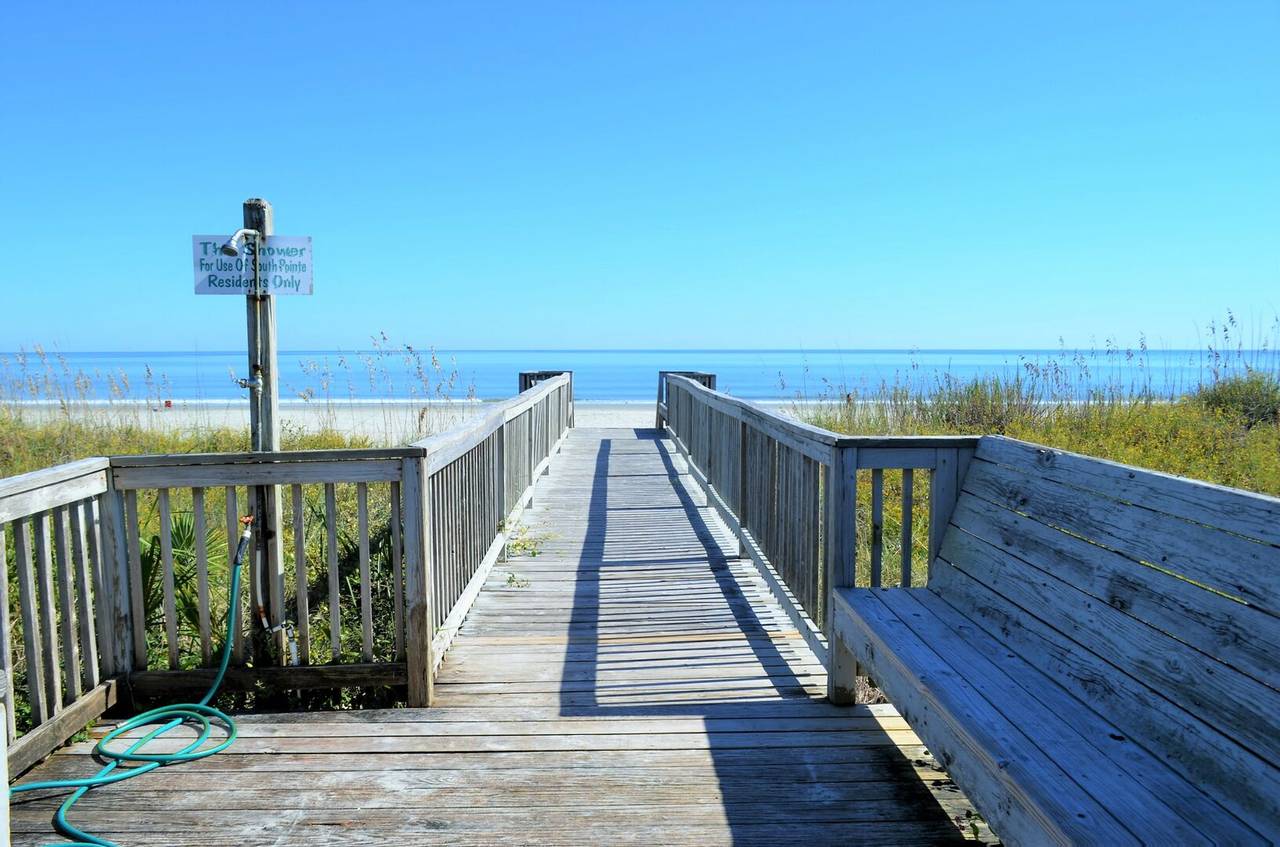 Walkway to beach with built-in bench and outdoor shower. Walkway to beach with built-in bench and outdoor shower.